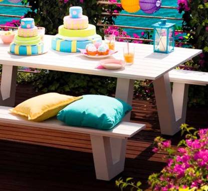 Mesa de madeira de conjunto de jardim com almofadas decorativas, bolos e acessórios decorativos, com petisco para piquenique